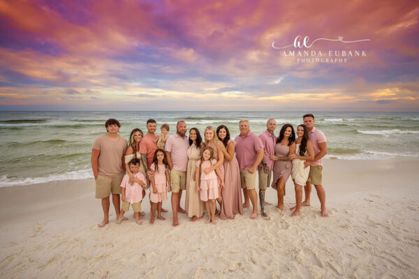 Seaside family photographer captures large extended family of twenty in pink and tan at sunset